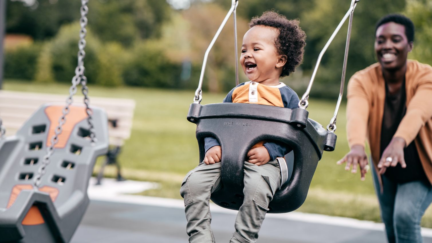 Mom pushes son in swing